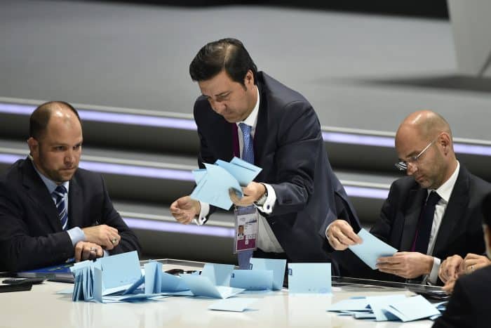 Officials sift through ballots .