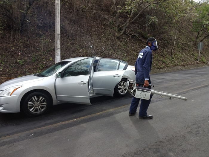 A Nicaraguan border worker fumigates our car, inside and out.