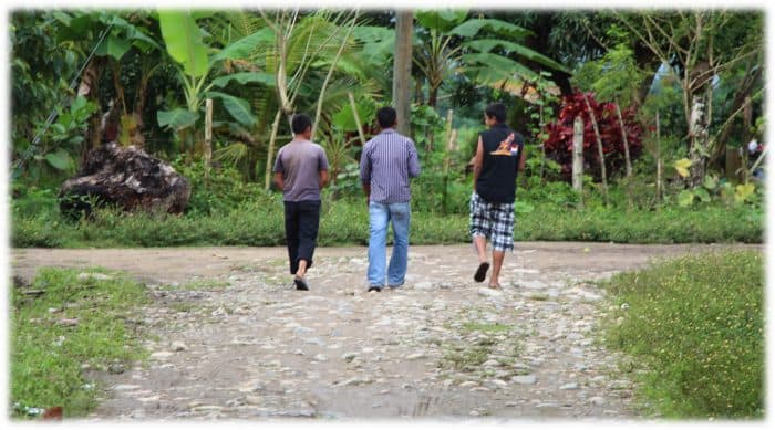 Three youth walk away from the grave of Gregorio Chávez near the community of La Panamá, Honduras, in 2013.