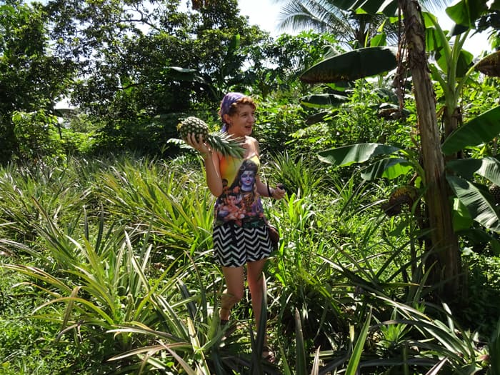 Katelynn Stratton of Smartsville, California, hoists a pineapple she just harvested.