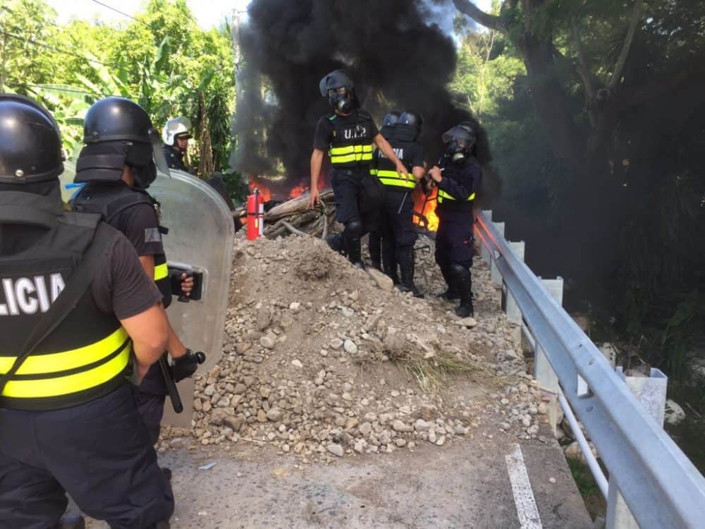Police work to put out a fire set by strikers today in Paquera.