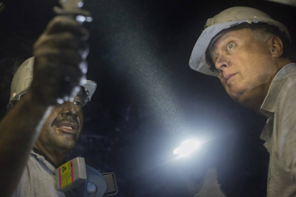 Miner Daniel Guerrero, left, shows a rock to Charles Burgess, director of Minería Texas Colombia in Muzo, Colombia on July 24, 2015.