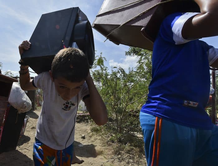Colombians deported from Venezuela who returned for some of their belongings and crossed them through the bordering Táchira River, stand on the banks of the river in Cúcuta, on the Colombian side, on Aug. 25, 2015.