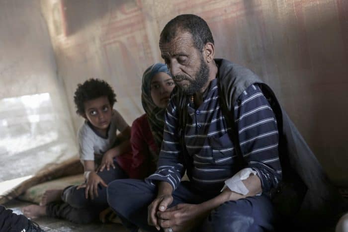 Faraj al-Ali, 43, who was left blind and suffering from kidney failure after being imprisoned by the Syrian regime in 2011, sits with his daughters.