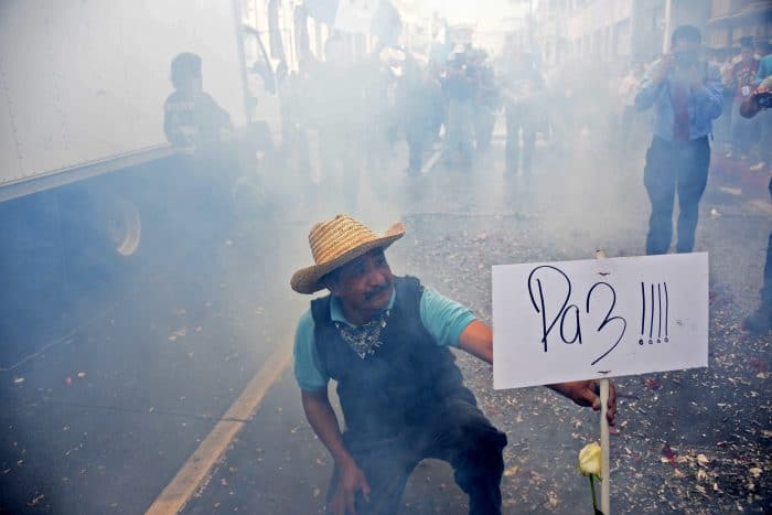 A man holds a sign declaring "Peace" after the Guatemalan Congress voted unanimously to strip embattled President Otto Pérez Molina's immunity.