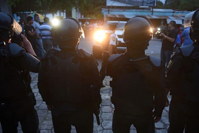 National police officers stand guard outside a polling station in San José del Golfo, 28 km northeast of Guatemala City, on Sept. 6, 2015. Guatemalans streamed to the polls Sunday in general elections held amid public disenchantment with government just days after the country's president was jailed on corruption charges.