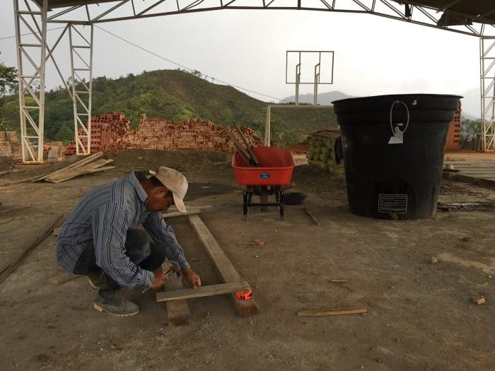 construction worker repairs soccer pitch
