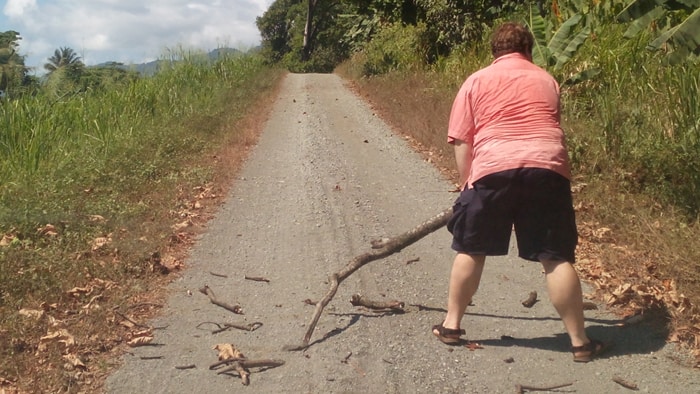 Jordan clears a branch from the road on the way to Luna Lodge.