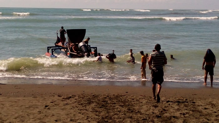 Workers unload construction materials from a strange-looking boat at Sirena.