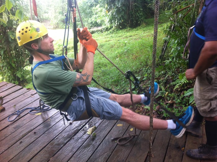 A visitor learns how to climb a tree with ropes.