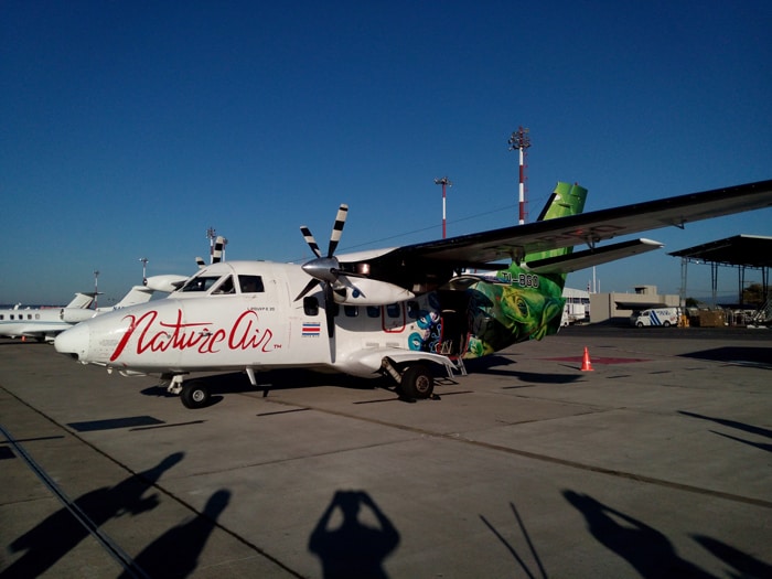 Silhouetted by morning sun, photographers snap pictures of a Nature Air Let L-410 turboprop at Costa Rica's Juan Santamaría International Airport.