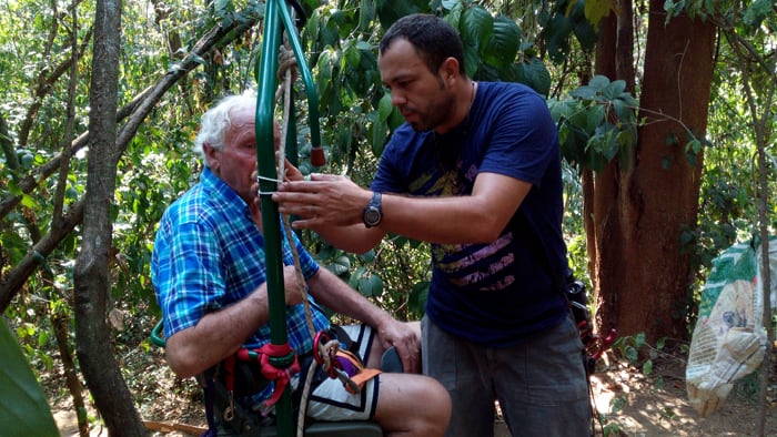 Carlos Jiménez adjusts a safety rope as Jim Smith prepares to ride the EcoTram.