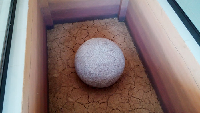 Stone sphere on display inside the museum.