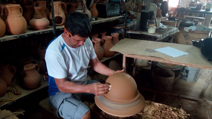 Smoothing out the bottom of the pot.