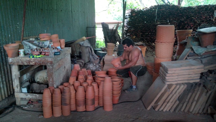 A worker taps new pots to make sure they aren't broken.