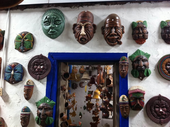 Some masks around a blue door.