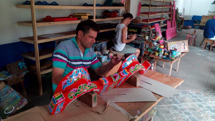 An artist named Edgar paints an oxcart yoke.