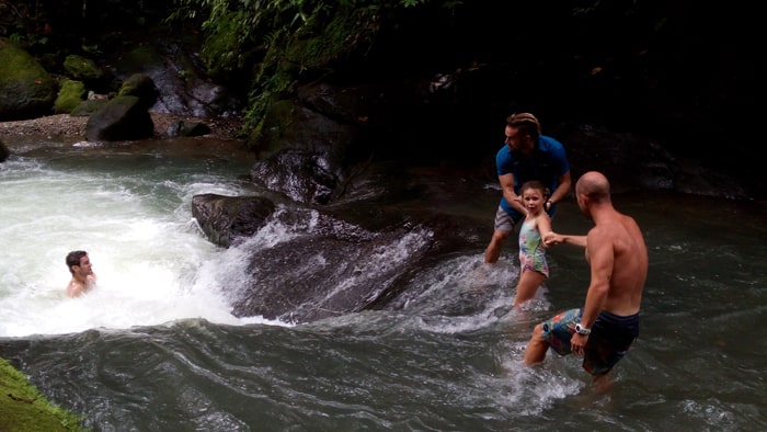 A father, a daughter and a couple of guides explore a waterfall at Punta Mala.