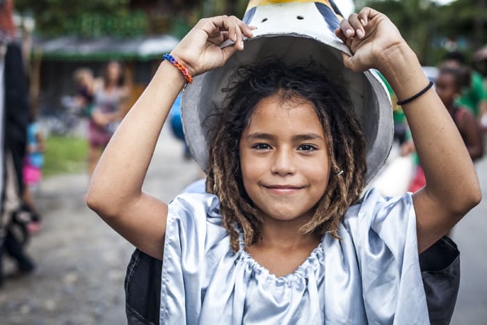 A child removes her bird mask in the Parade of the Birds.