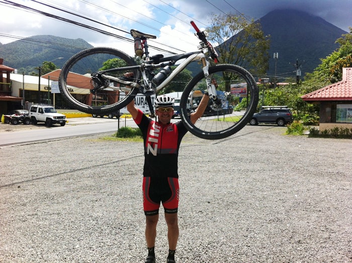 A San José cyclist celebrates in Fortuna after completing a circuit of Lake Arenal.