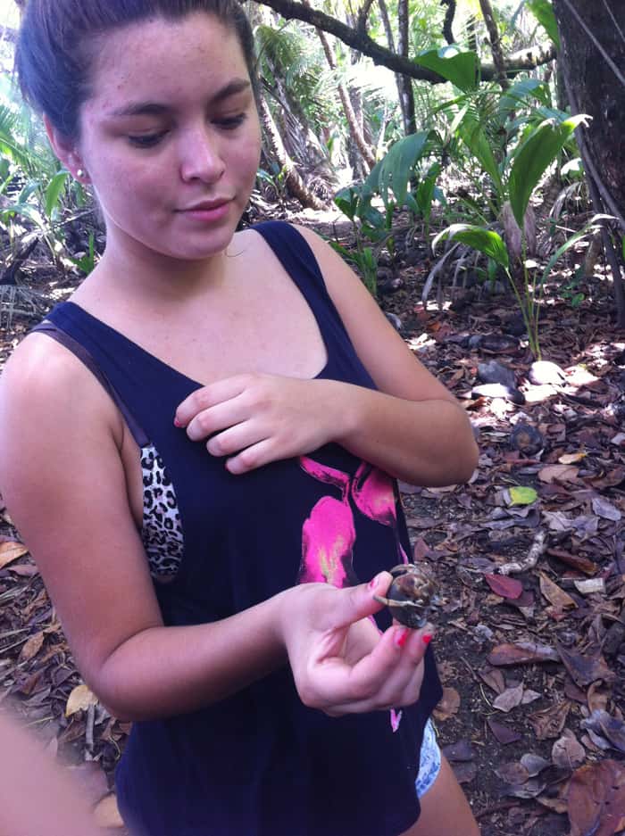Priscilla holds a big hermit crab, which probes her fingers with its claws but can't reach them with its pinchers.