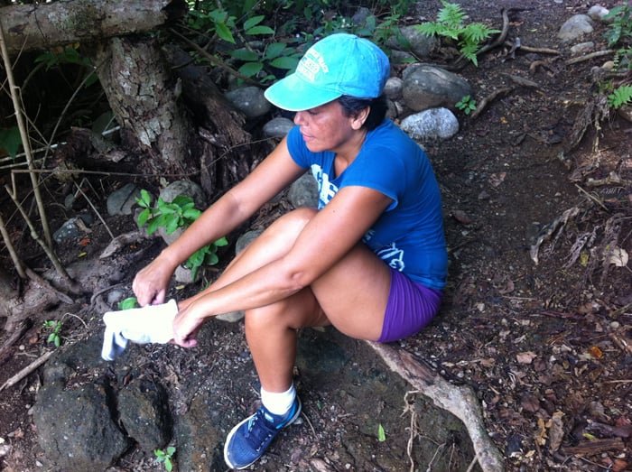 Guiselle puts on her shoes again after crossing the knee-high Río Madrigal.
